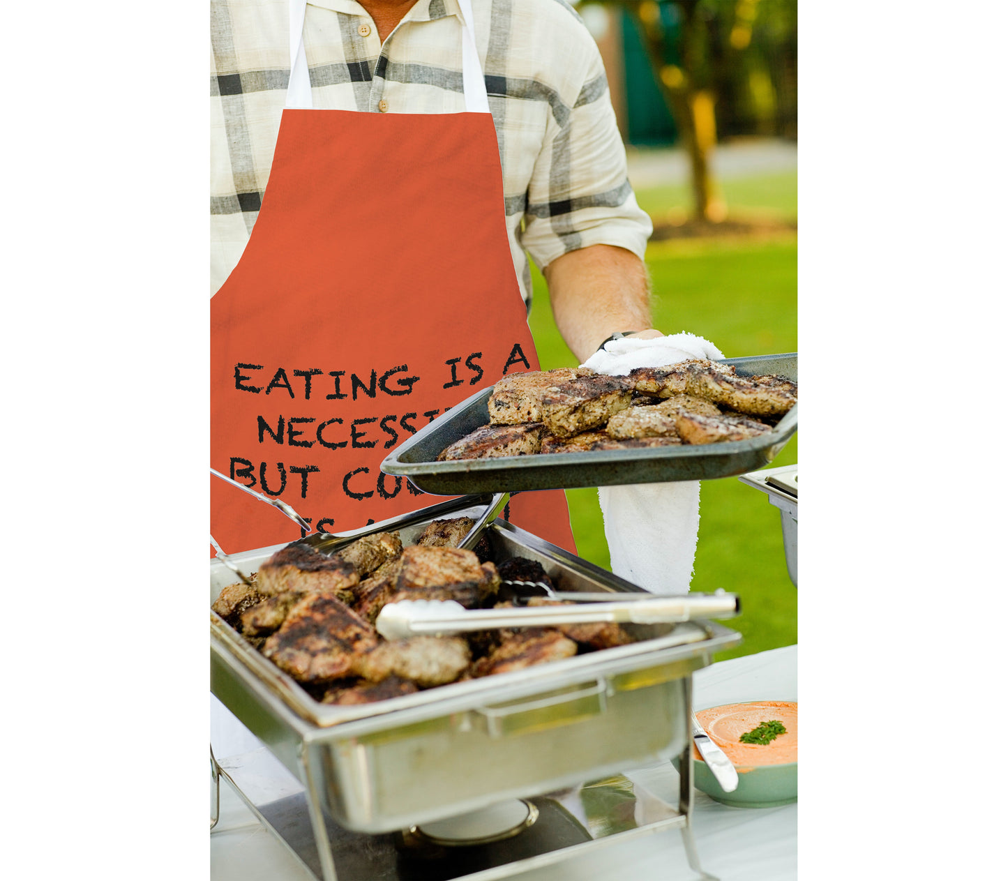 Person Wearing Personalised Apron. Red Background with Personalised text. Text says 'Eating is a necessity but cooking is an art'.