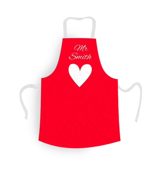 Personalised Apron Valentines Day. Red Background and White Heart, with personalised text over the top. Texr says 'Miss Jones'.