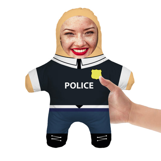 Mini Doll Police Outfit. Police Uniform and Ladies Face. Front View. A Hand Picking Up The Doll.