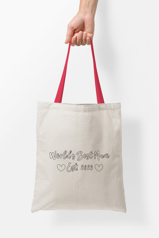 Mothers Day Tote Bags, Worlds Best Mum | Fab Gifts | Handel Red | Text: Worlds Best Mum Est. 2023 | Two heart images | Person holding the bag